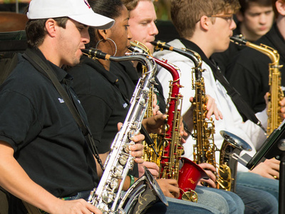 students play saxophones while seated in a band