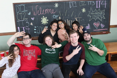 students pose in a group with three fingers raised