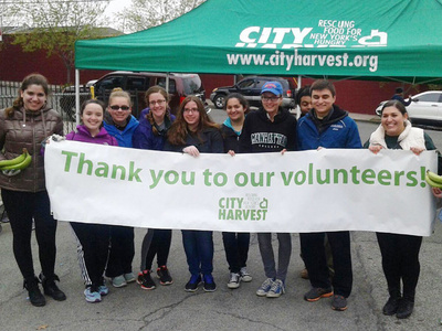 members of the Lasallian Outreach Collaborative hold a banner at an outdoor event