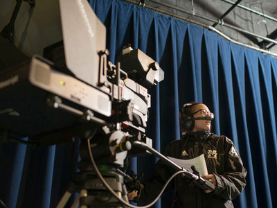 a person operates a large, mounted film camera