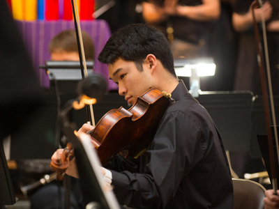a student plays an instrument in an orchestra