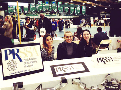 students sit at a promotional table at a conference event