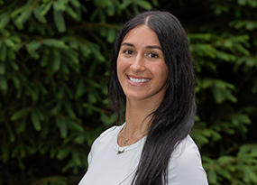 Portrait of Alexa Fox, Admissions Counselor, smiling outdoors against a green background.