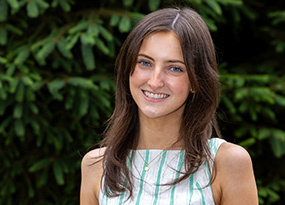 Portrait of Kelly Kennedy, Admissions Counselor, smiling outdoors against a green background.