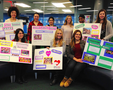 students hold posters highlighting service areas