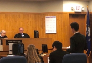 students compete in a mock trial within a court room