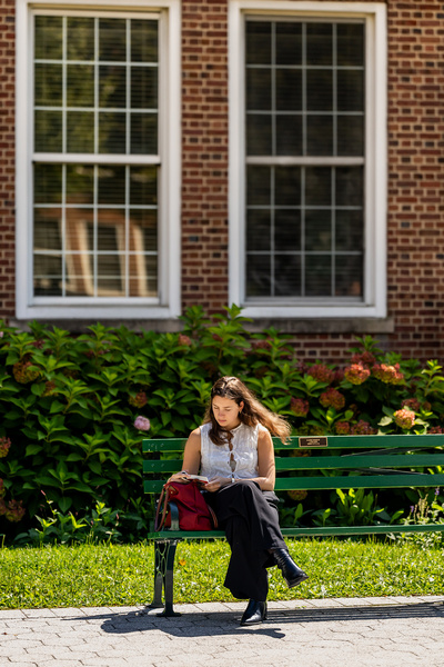 Manhattan University student smiling sitting outside studying
