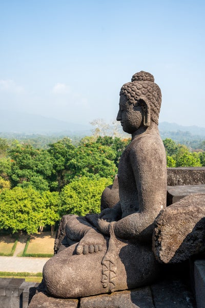 Buddha statue meditating at the Borobudur Temple in Indonesia