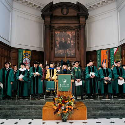 Academic leaders gather on stage during the Manhattan University presidential inauguration.