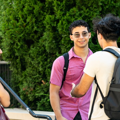 Manhattan University students smiling talking outside on the Quad