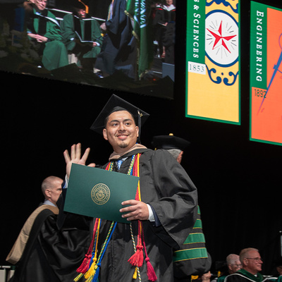 Manhattan University Student walking across the stage at Commencement