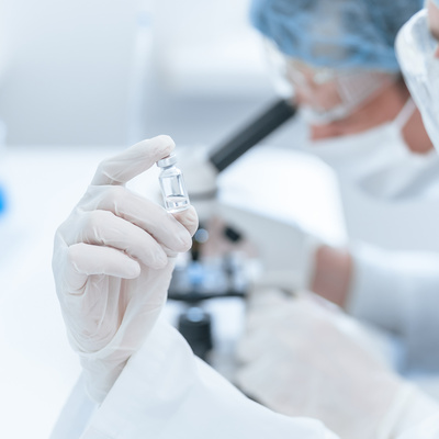 A close up ampoule with a new vaccine in the hands of a scientist