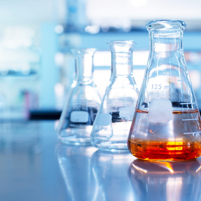 orange solution in glass beaker in a laboratory