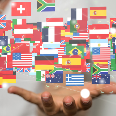 illustration of many countries flags floating about someones hand.