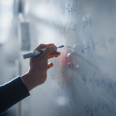 Teacher Writing Equations on a Whiteboard with Mathematical Formulas. 
