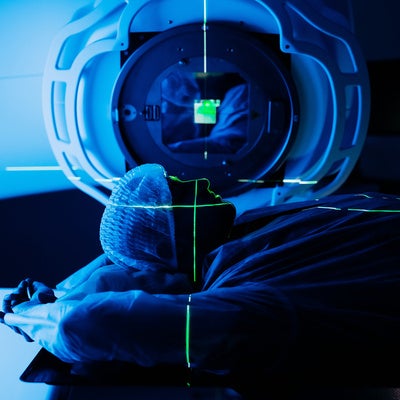 Linear accelerator in oncology treatment room, patient positioned for radiation therapy, with advanced technology