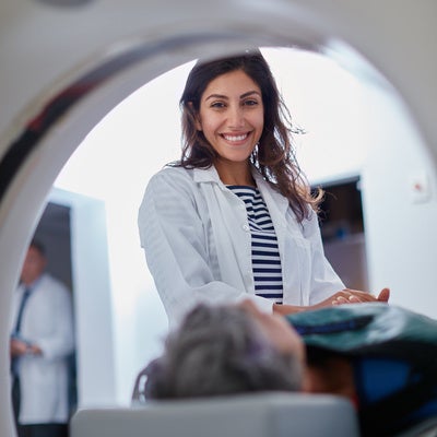 Doctor, mri and portrait of woman with patient to comfort in hospital for machine scanning. Ct scan, holding hands or smile of medical professional with senior person in radiology test for healthcare
