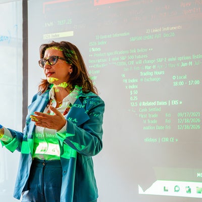 Photo of professor teaching in the Bloomberg Lab with data screen projecting on her and the wall