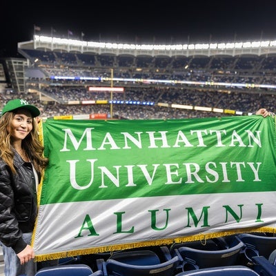 Manhattan University students holding up an alumni banner at a Yankee's game